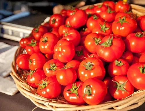 Basket of ripe red tomatoes at a market stall